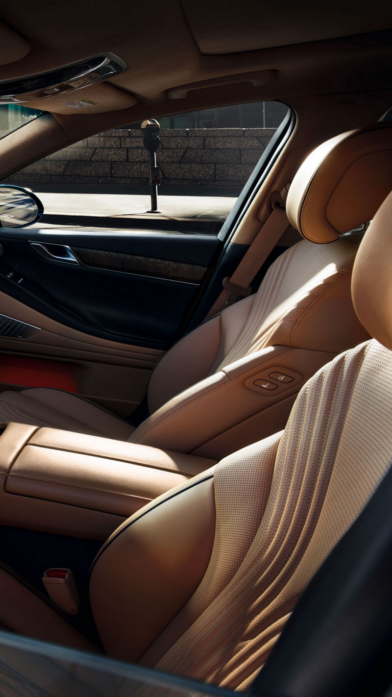 View through the window of the front compartment of the Genesis G80 with beige and black interior