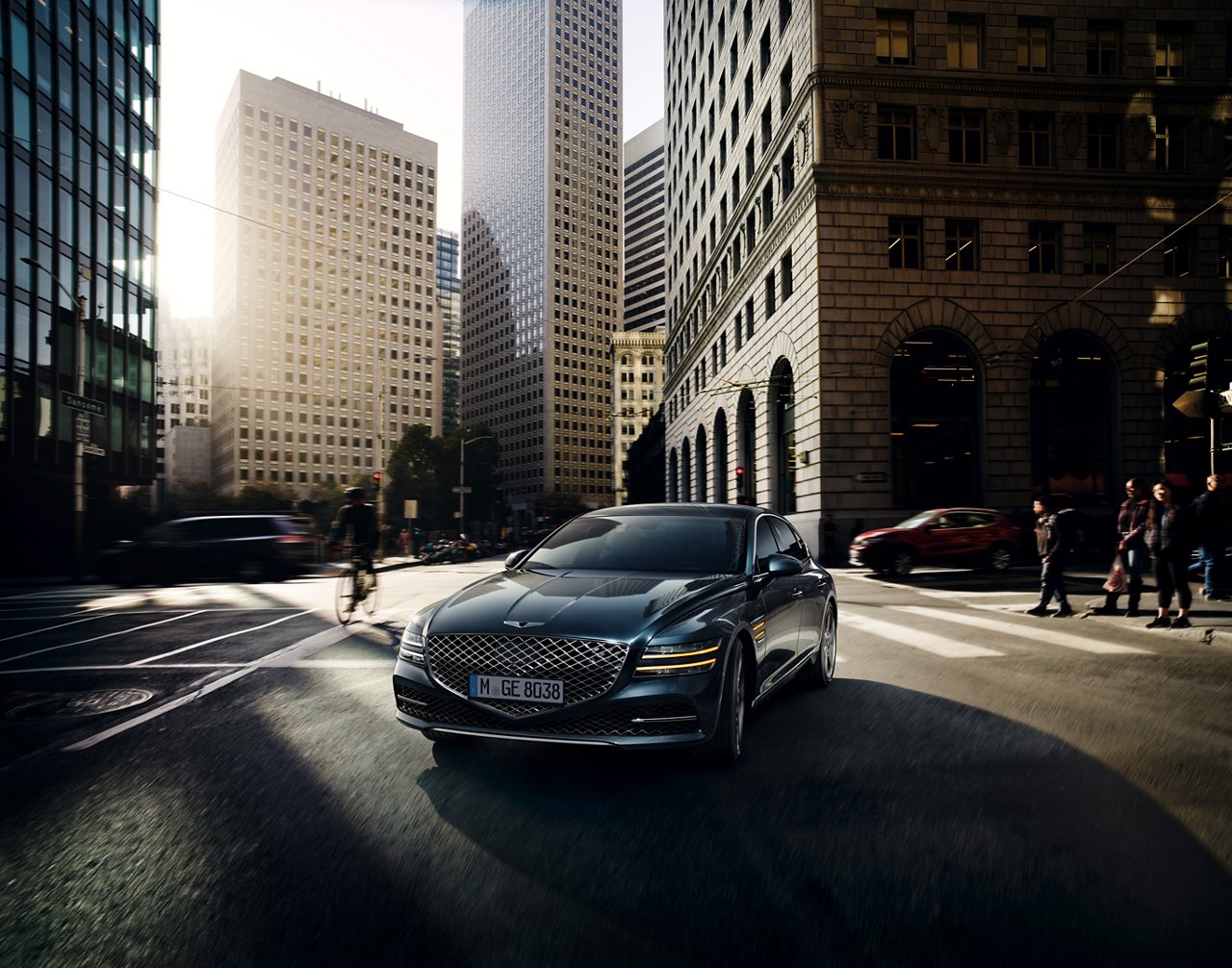 A black luxury sedan turns left on a city street, surrounded by skyscrapers