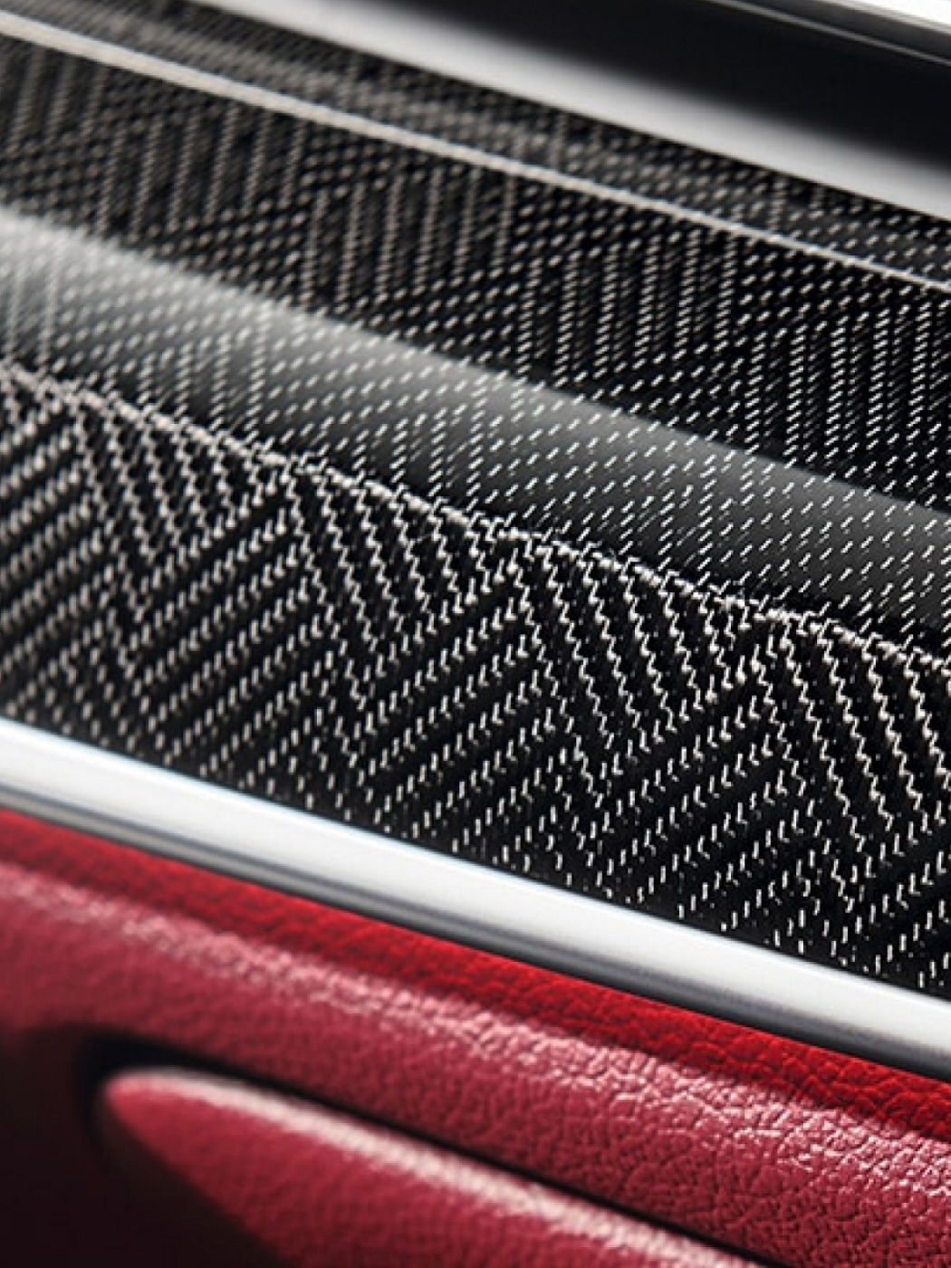 Close-up of the Genesis G80's unique interior trims with a herringbone pattern and red leather detail.