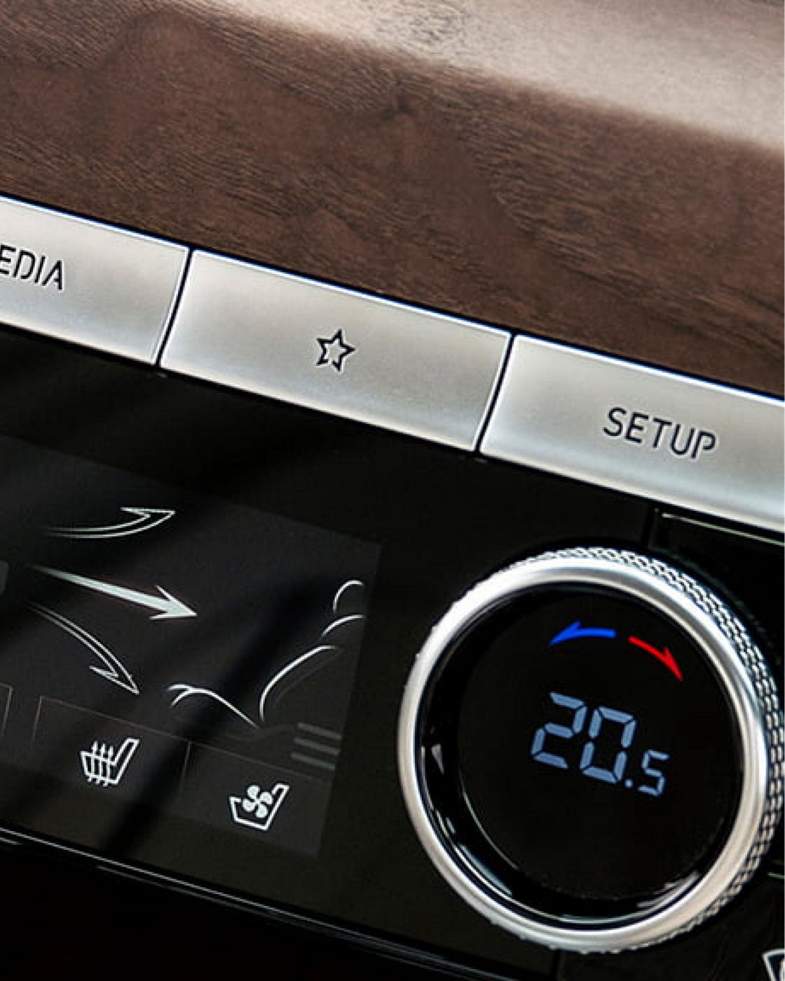 Close-up of the Genesis G80's control panel with wood trim and temperature settings.