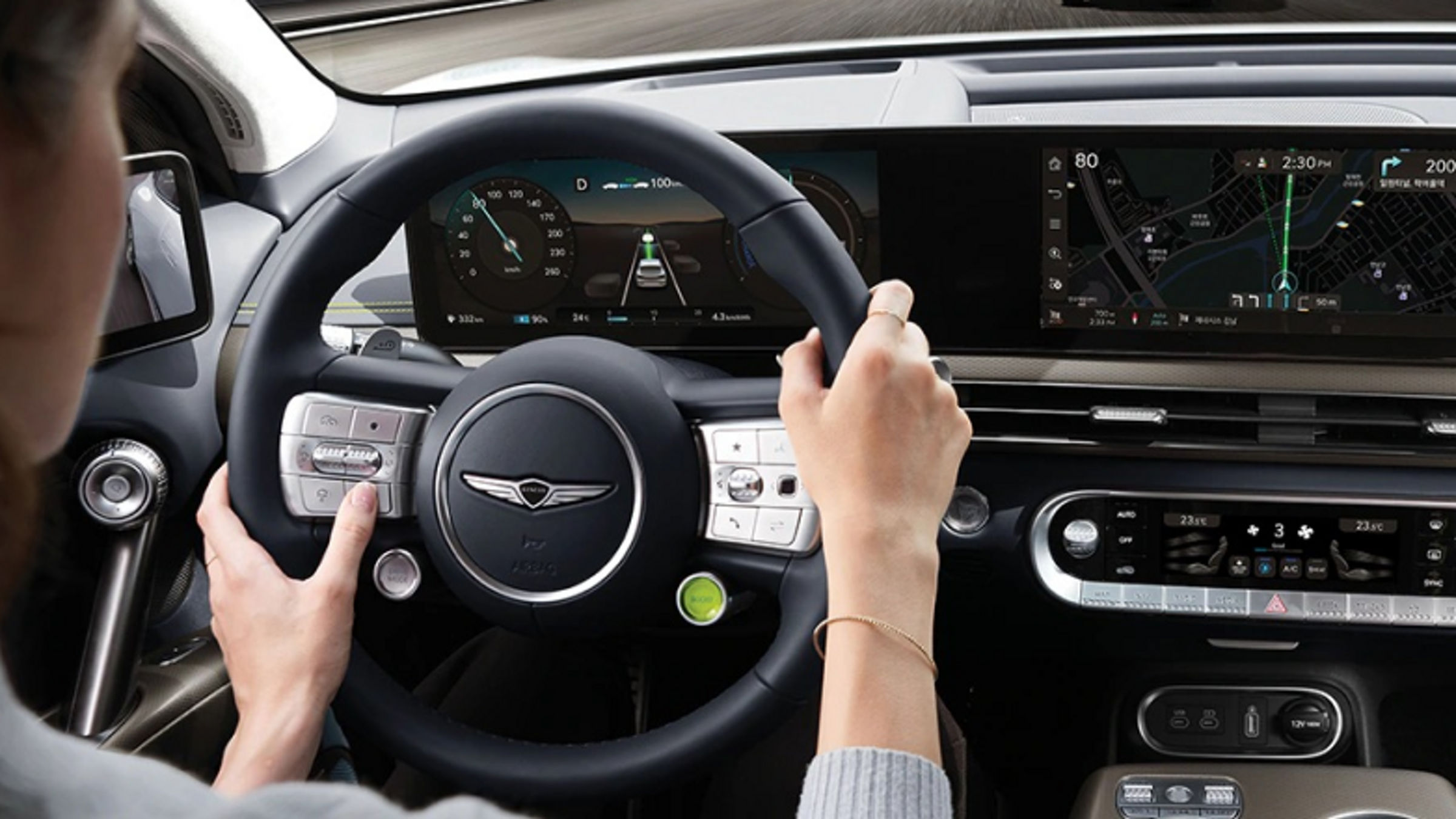 A woman driving the GV60, holding the steering wheel with both hands.