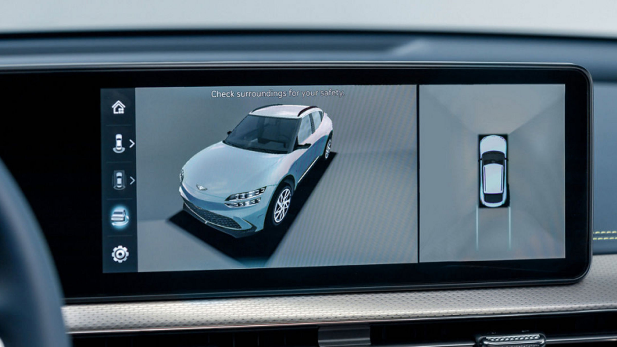 The rear camera of the GV60 showing two angles at once, with a black car visible.