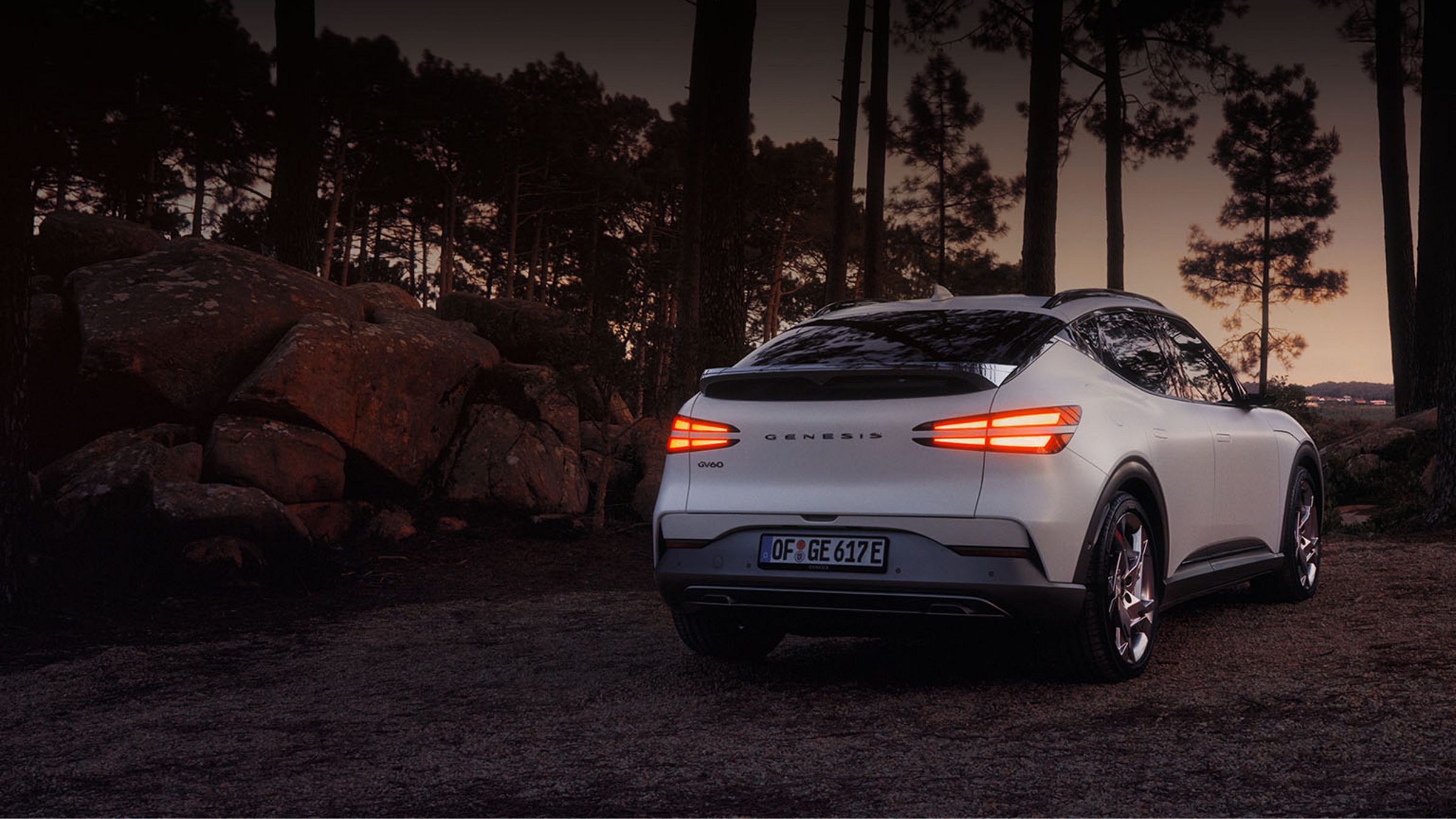 Rear side of a white GV60 parked in the forest 