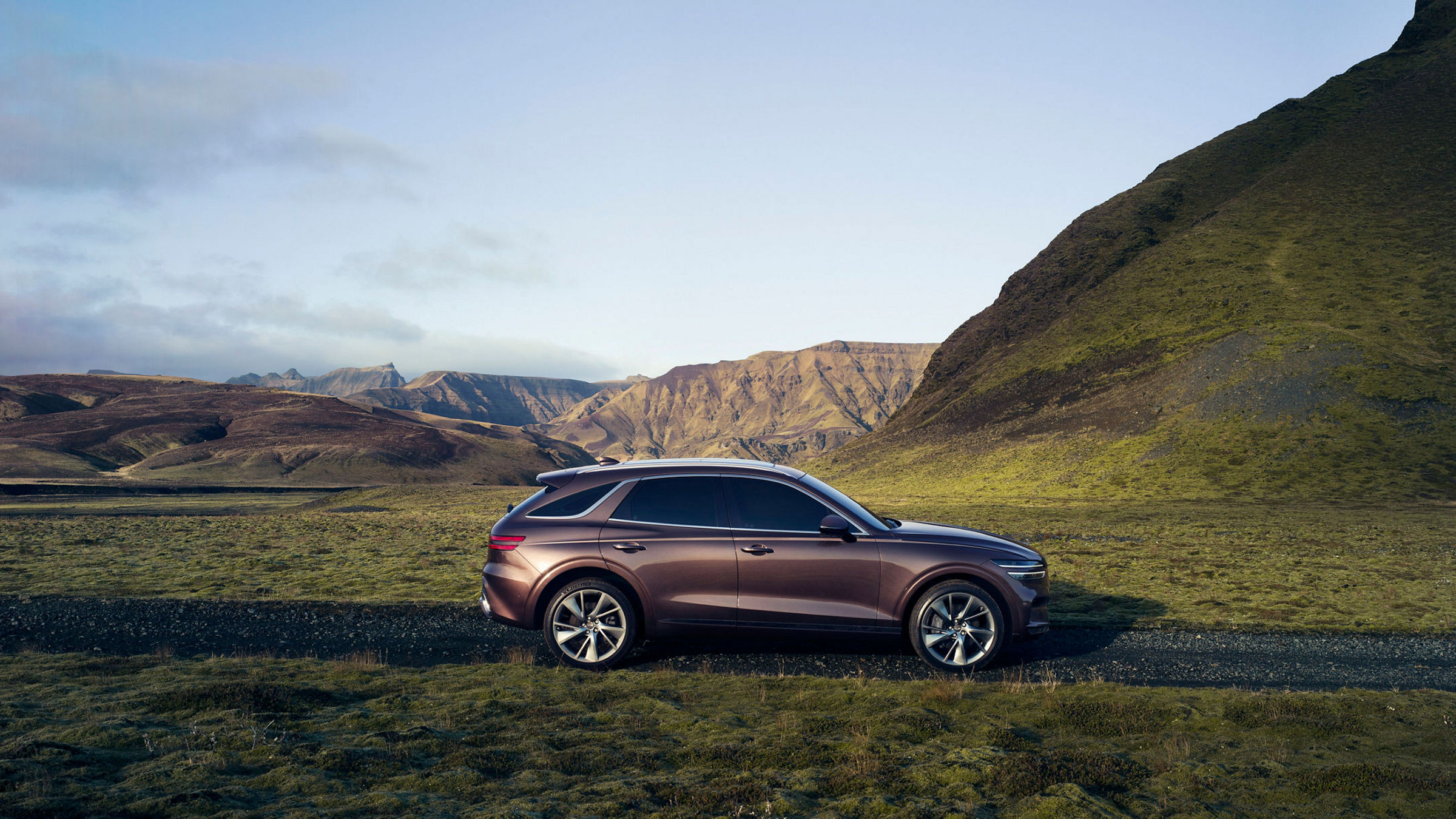 Genesis GV70 parked on a scenic mountain road, blending elegance with nature's beauty.