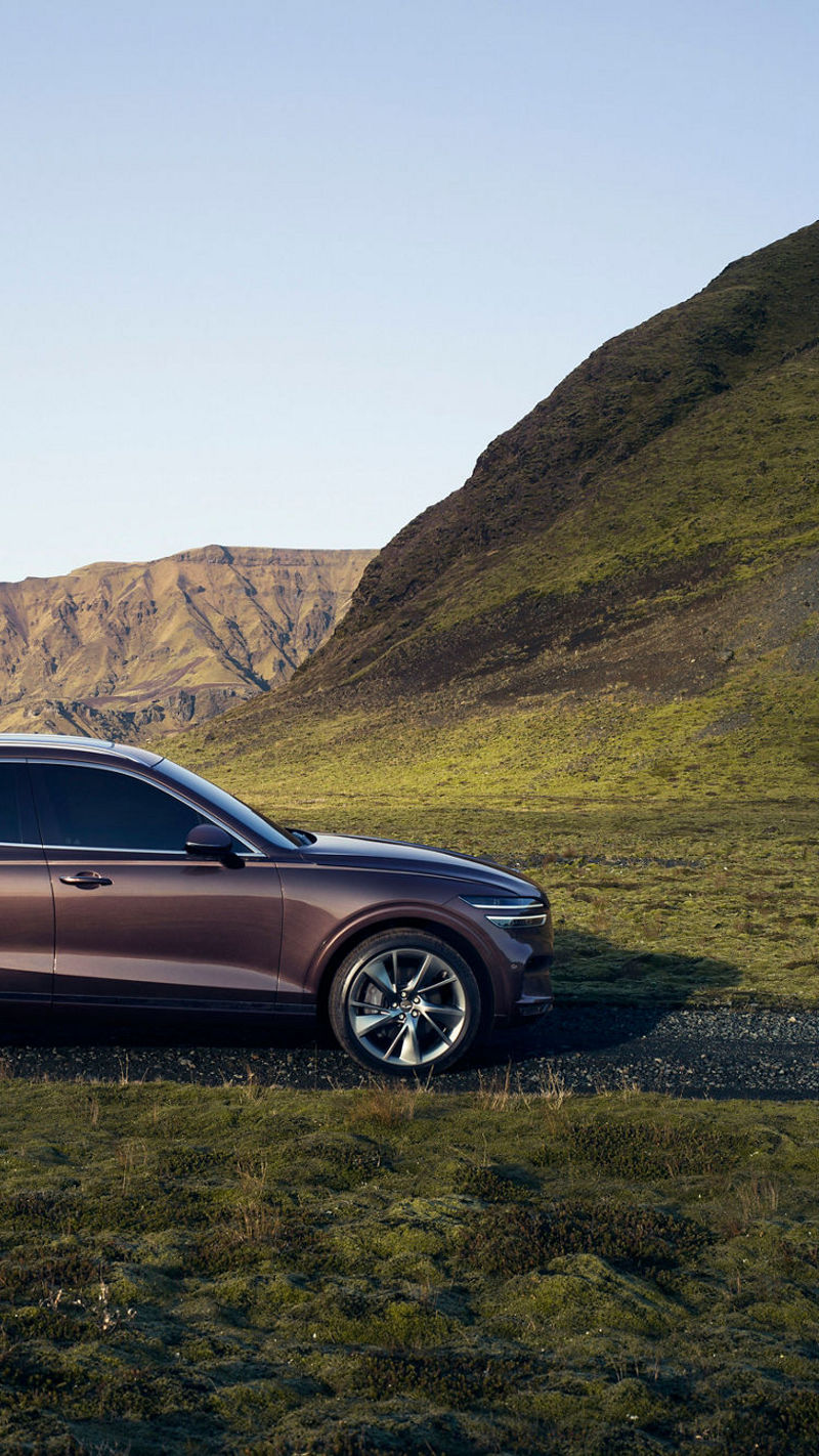 Genesis GV70 parked on a scenic mountain road, blending elegance with nature's beauty.