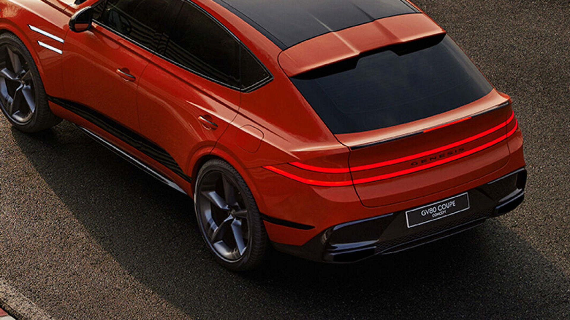 Rear-side view of the Genesis GV80 Coupe in orange, showcasing sleek taillights and a sporty design