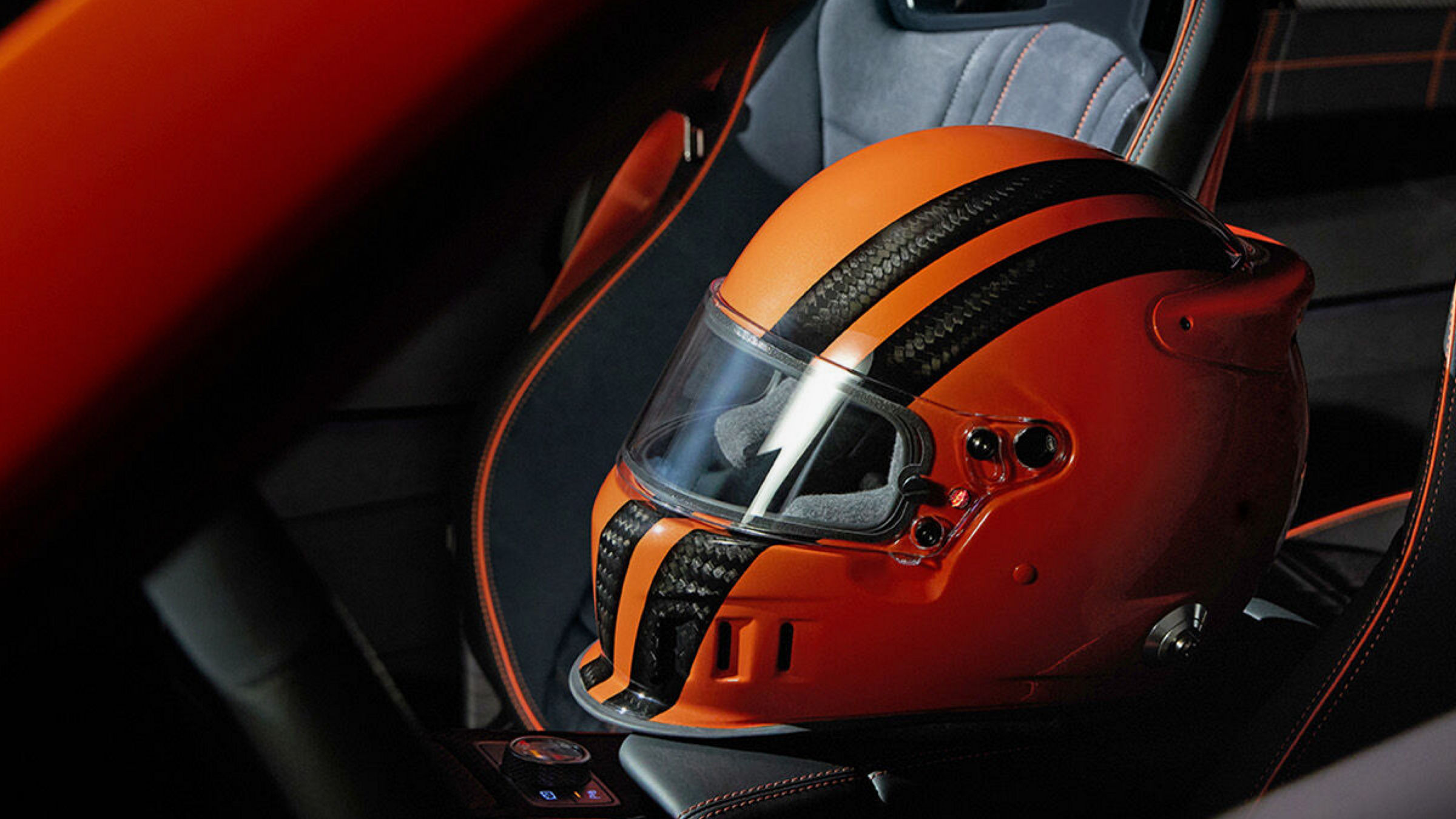 Orange helmet with black stripes placed on the seat inside the Genesis GV80 Coupe