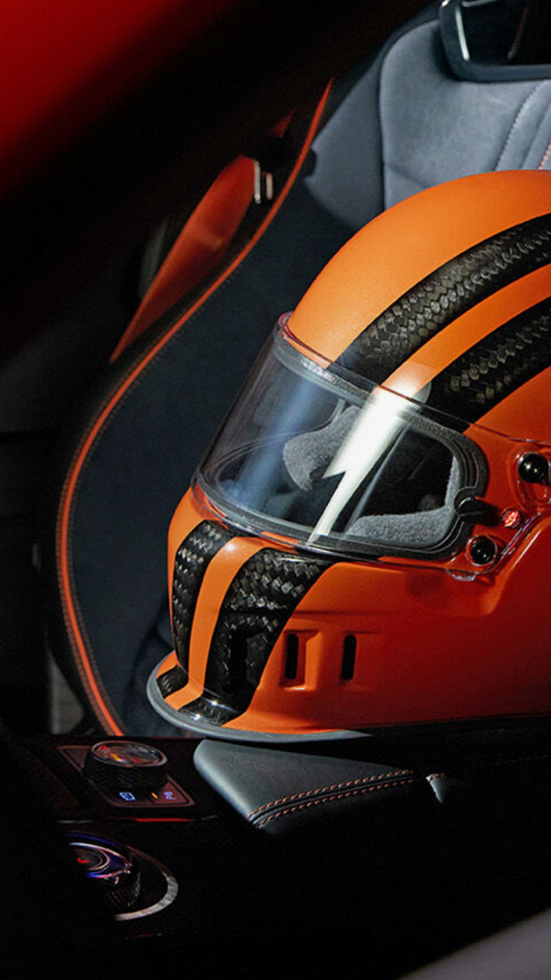 Orange helmet with black stripes placed on the seat inside the Genesis GV80 Coupe