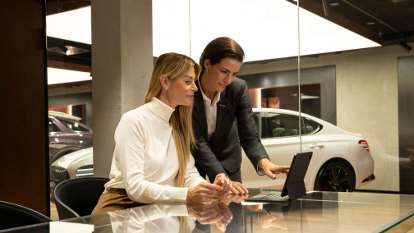 Customer advisor shows a woman something on a laptop