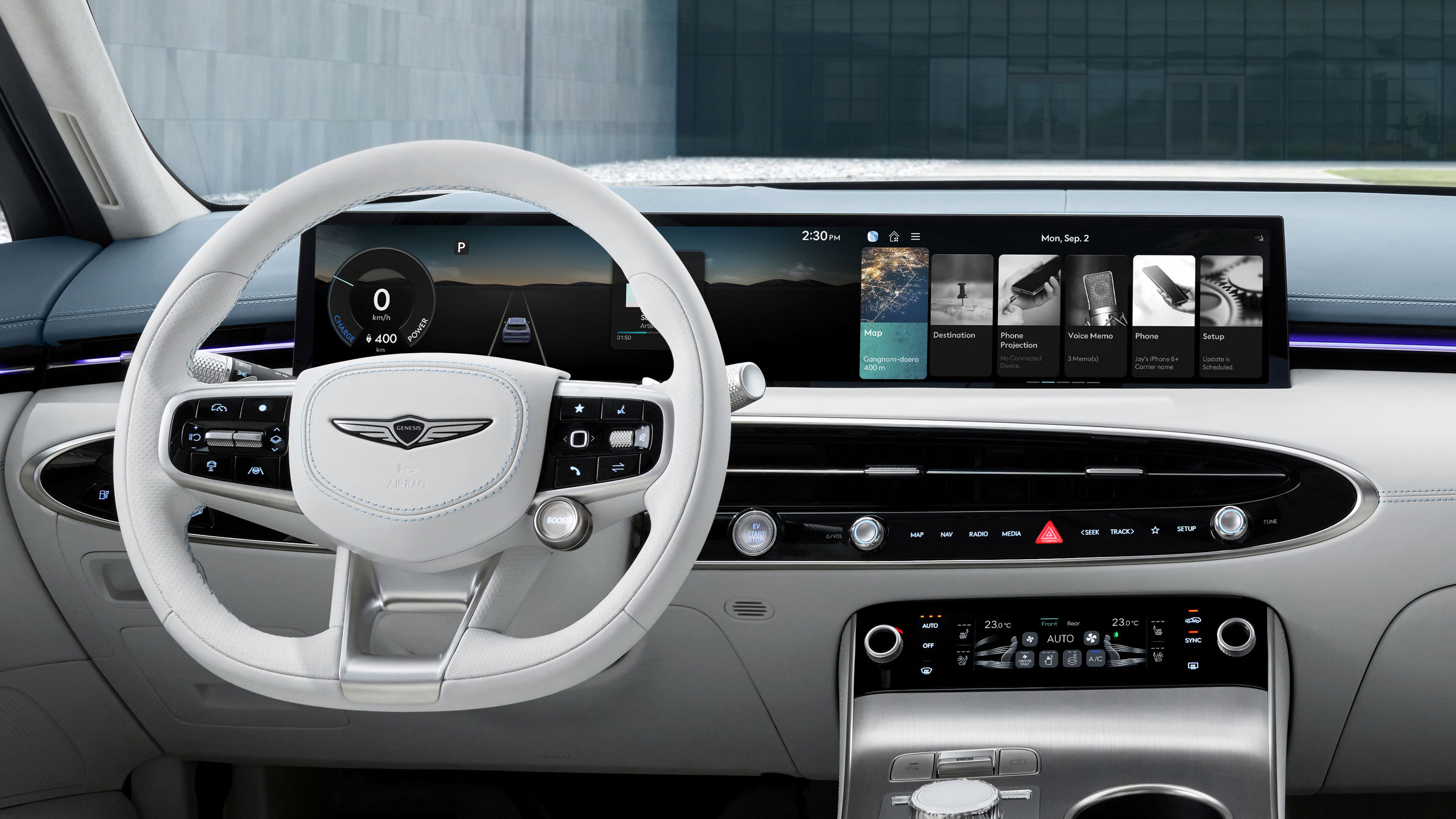 Vista detallada de los asientos del conductor y del acompañante del Electrified GV70, incluyendo una variedad de botones cerca de la manilla de la puerta, así como el volante, la pantalla y un conjunto de botones de control.