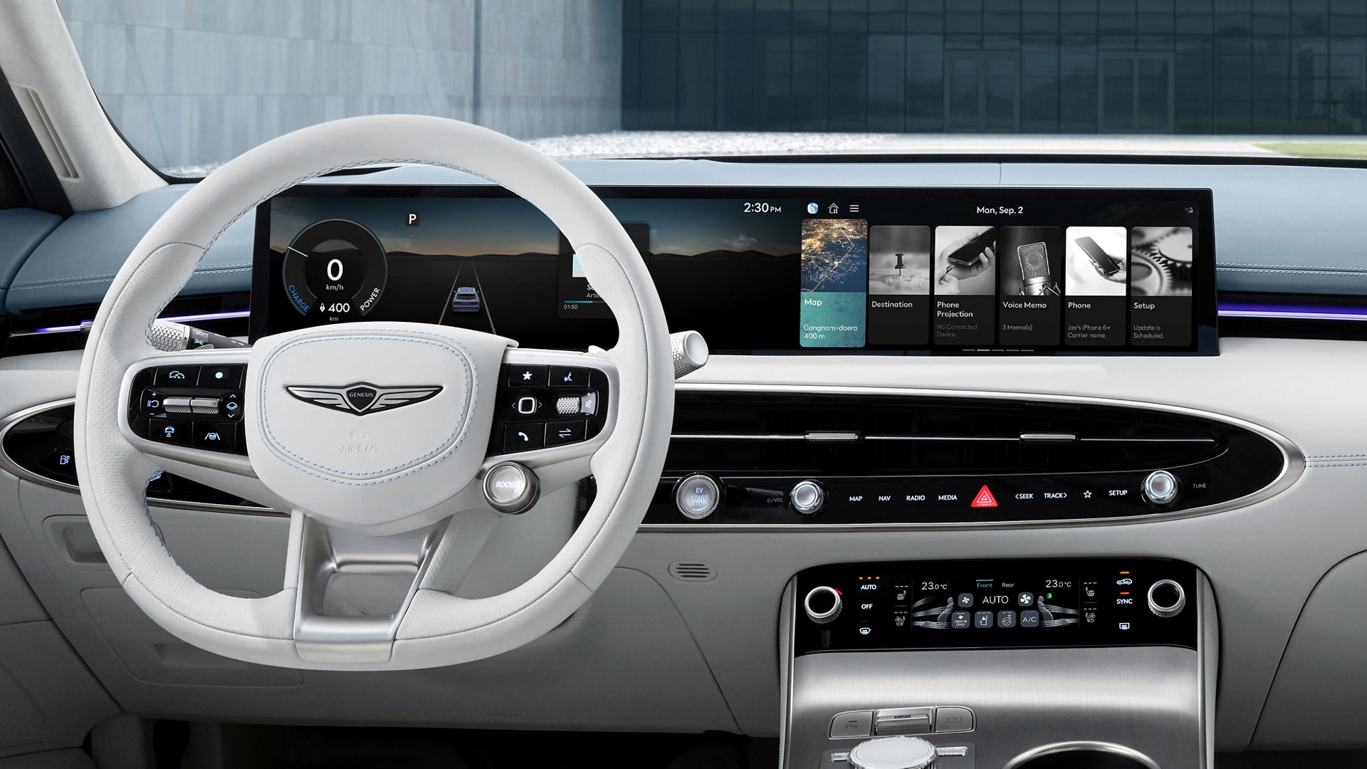 A detailed view of the driver and front passenger seats of the Electrified GV70, including a variety of buttons near the door handle as well as the steering wheel, display screen, and a cluster of control buttons.
