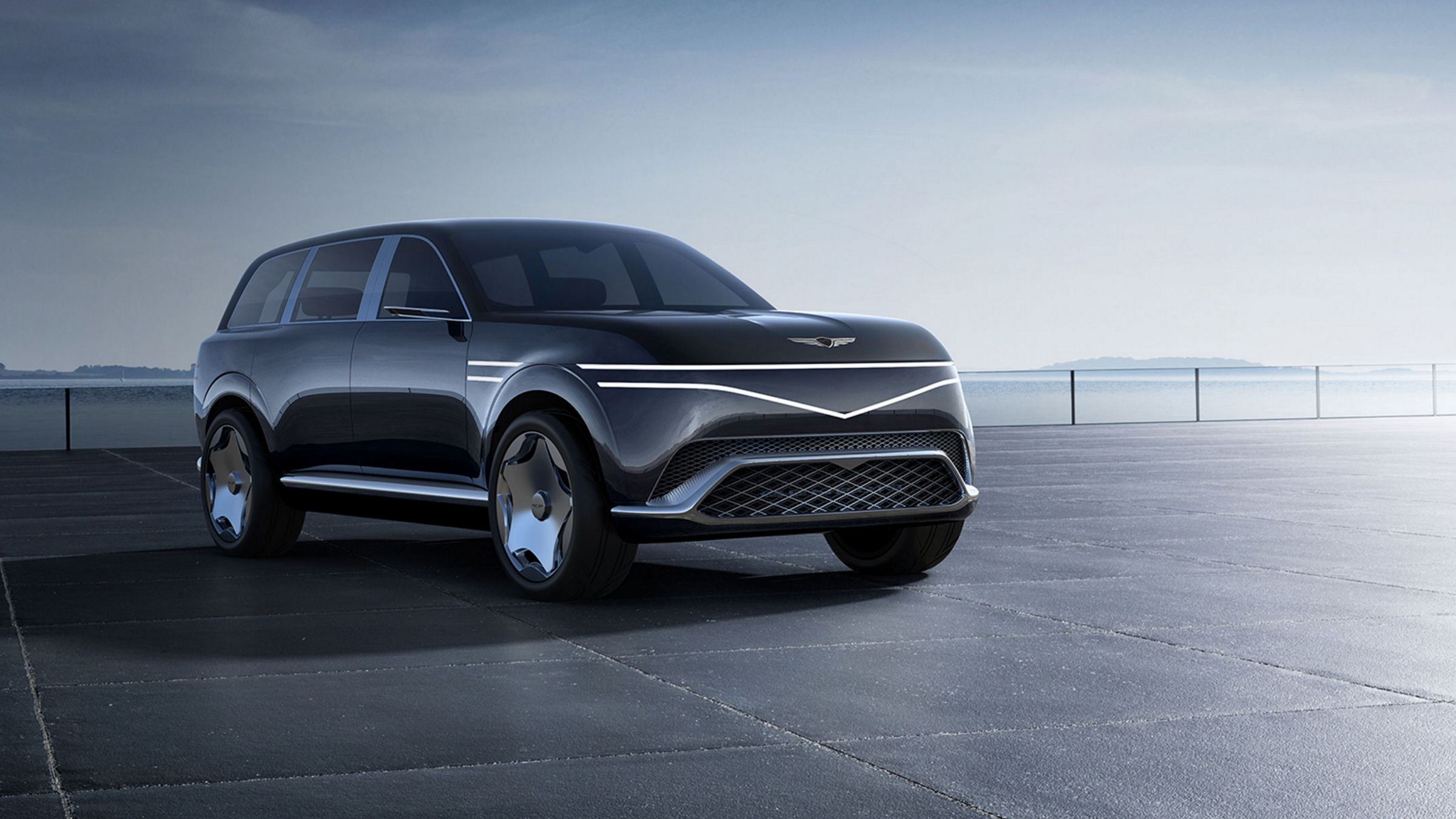 The night view of Seoul reflected on a moon jar is seen, overlapping with the two-line design of Genesis. A parked Genesis Neolun Concept is shown, with a brightly colored sky blending various colors in the background."