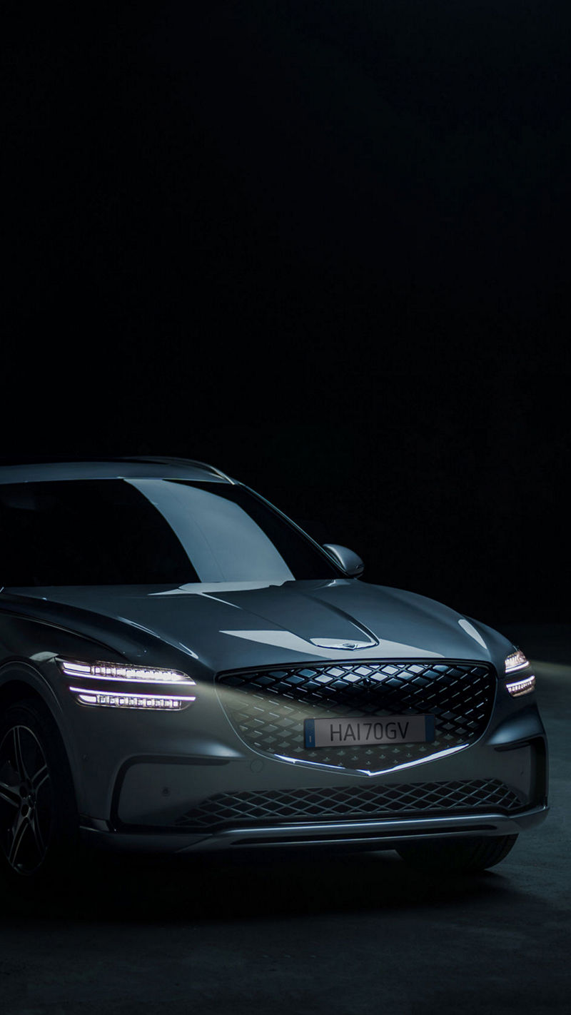 La Genesis Electrified GV70 è parcheggiata in uno spazio esterno con una superficie in cemento a vista.