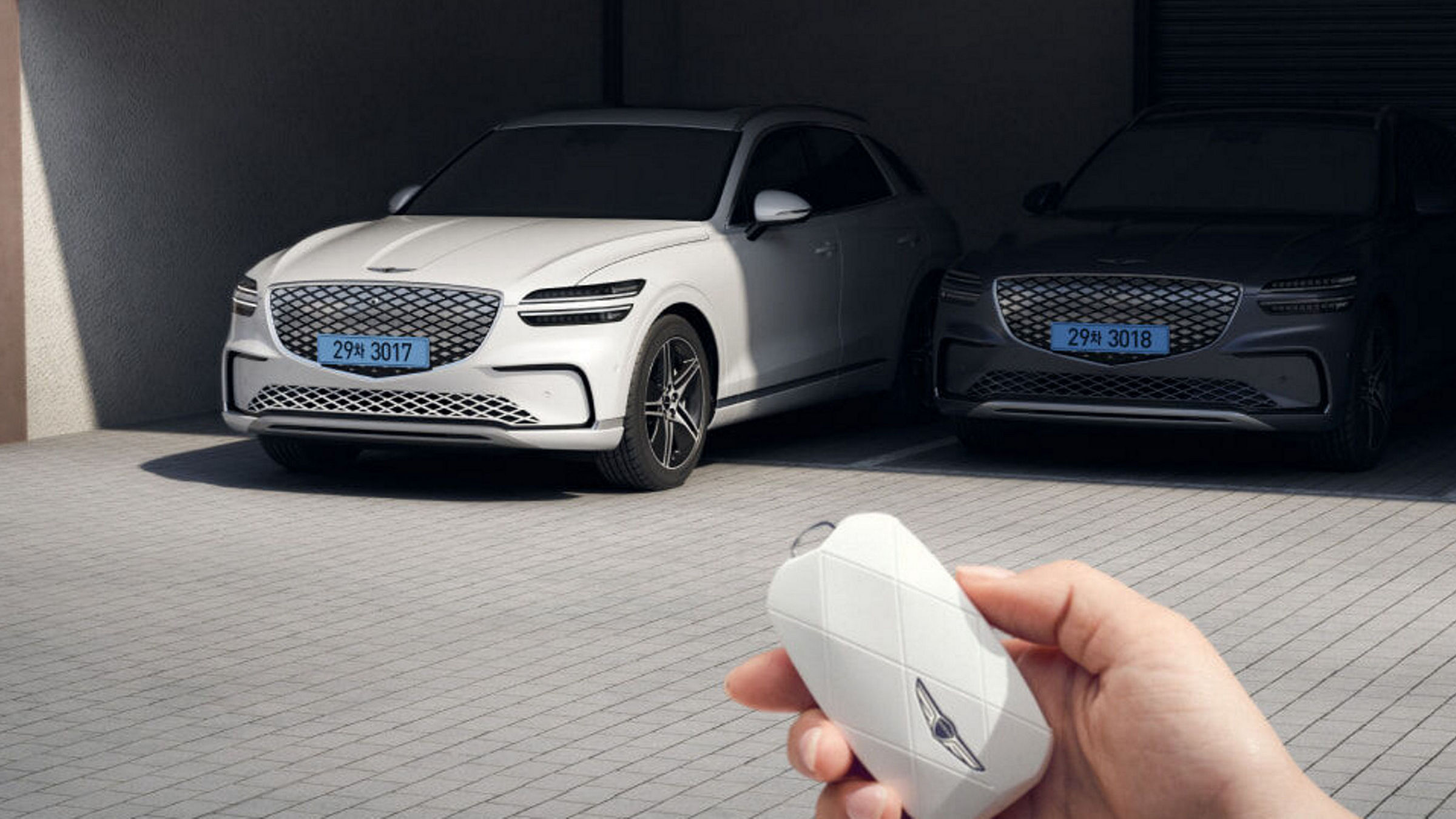 Un usuario está controlando su vehículo de forma remota utilizando una llave inteligente desde fuera del vehículo. 