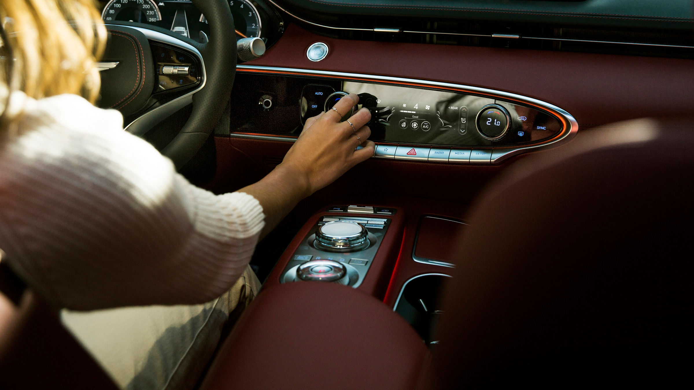 A woman at the wheel of a car switches on the air conditioning