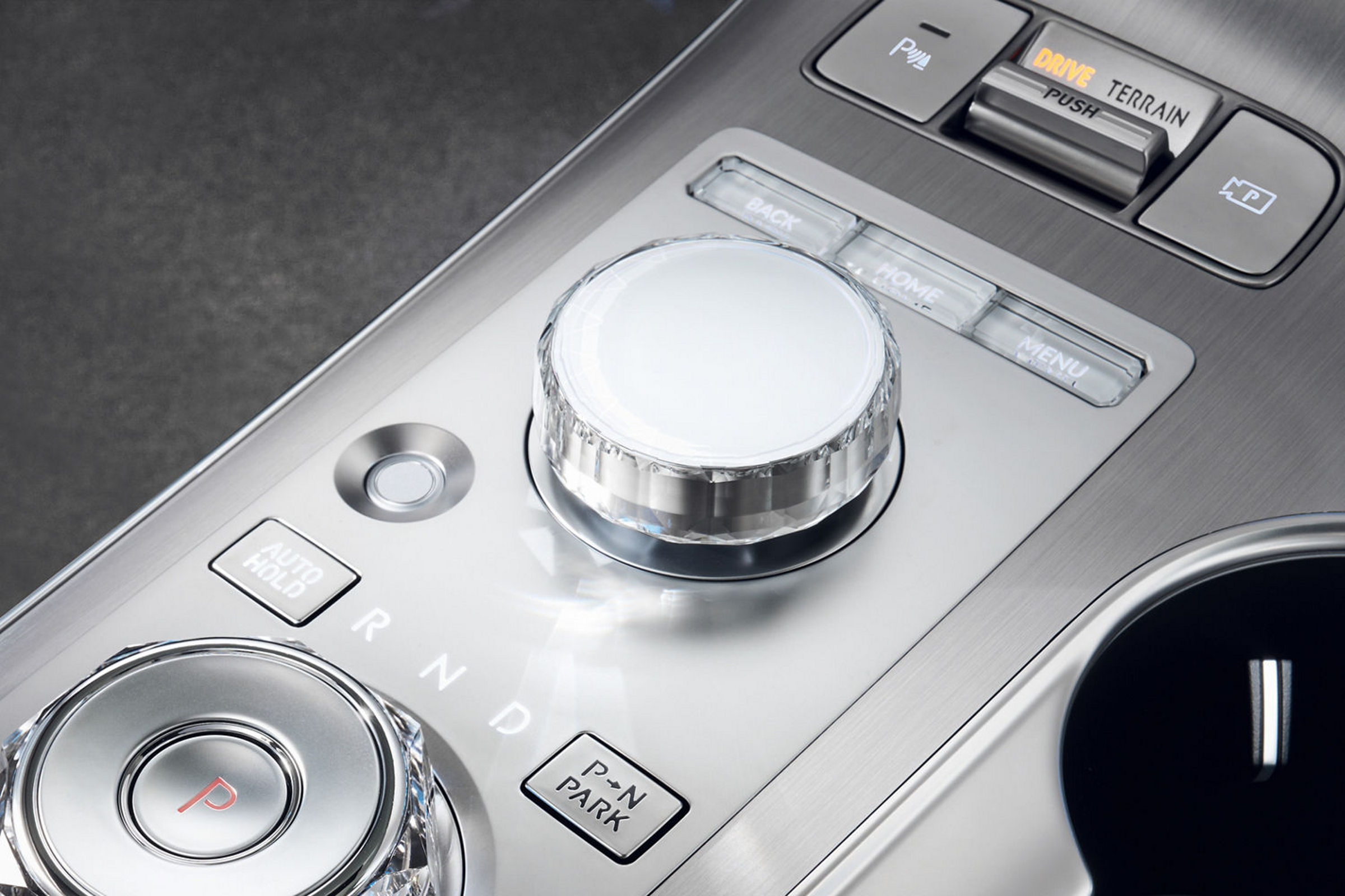 Vista del controlador integrado entre los asientos del conductor y del acompañante, con varios botones y mandos de control.