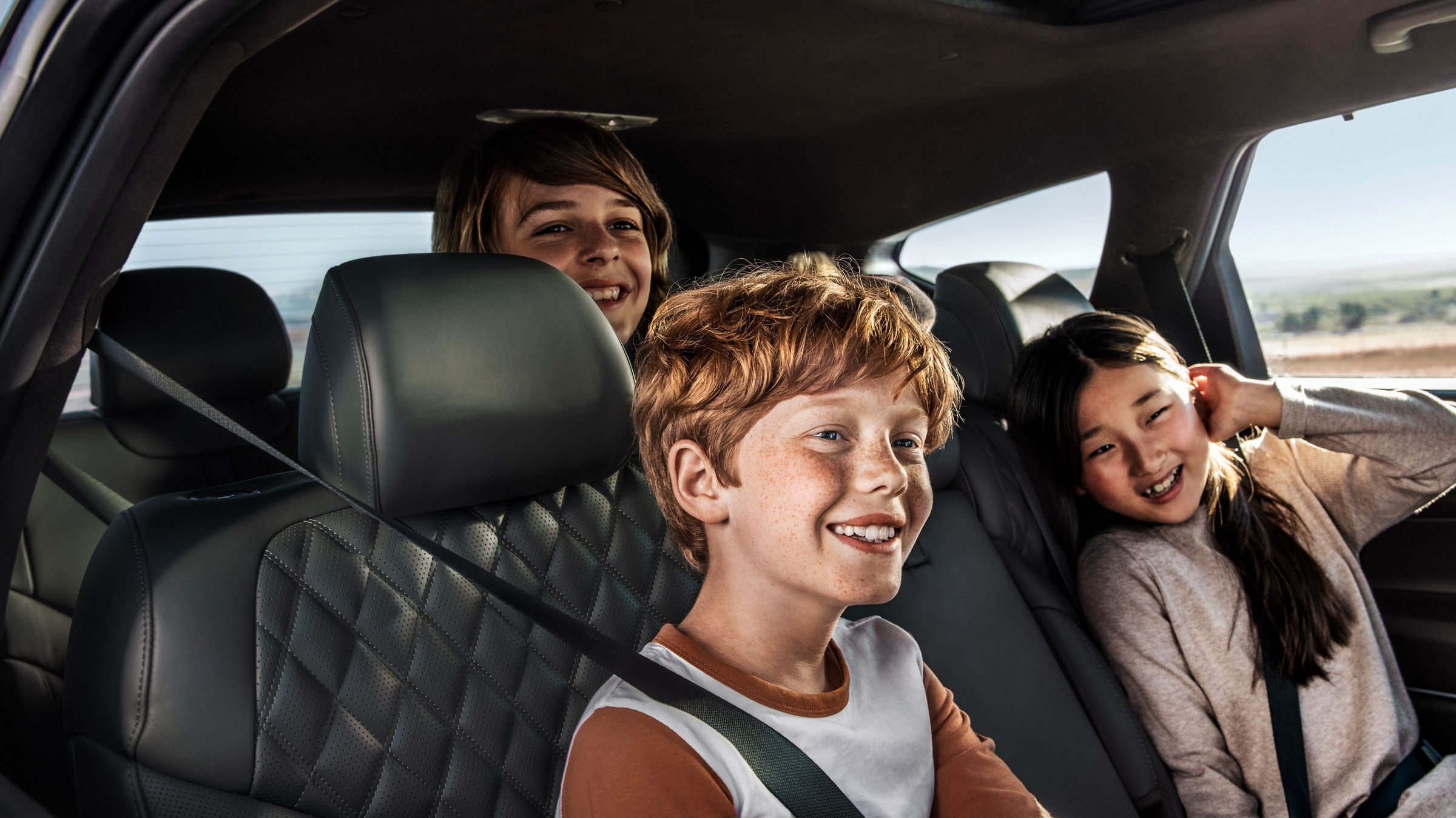 Boy and girl laughing in the front seats of a car