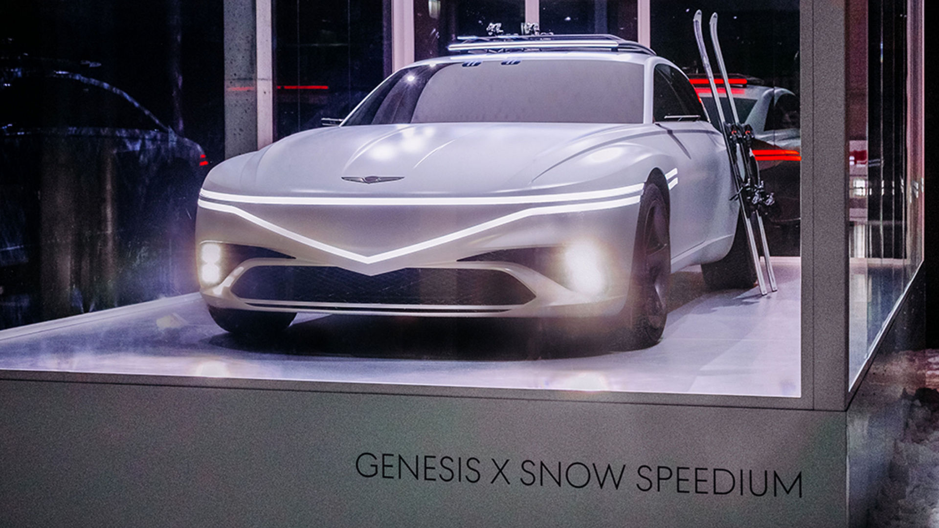 The white-colored X Snow Speedium concept vehicle with the lights turned on