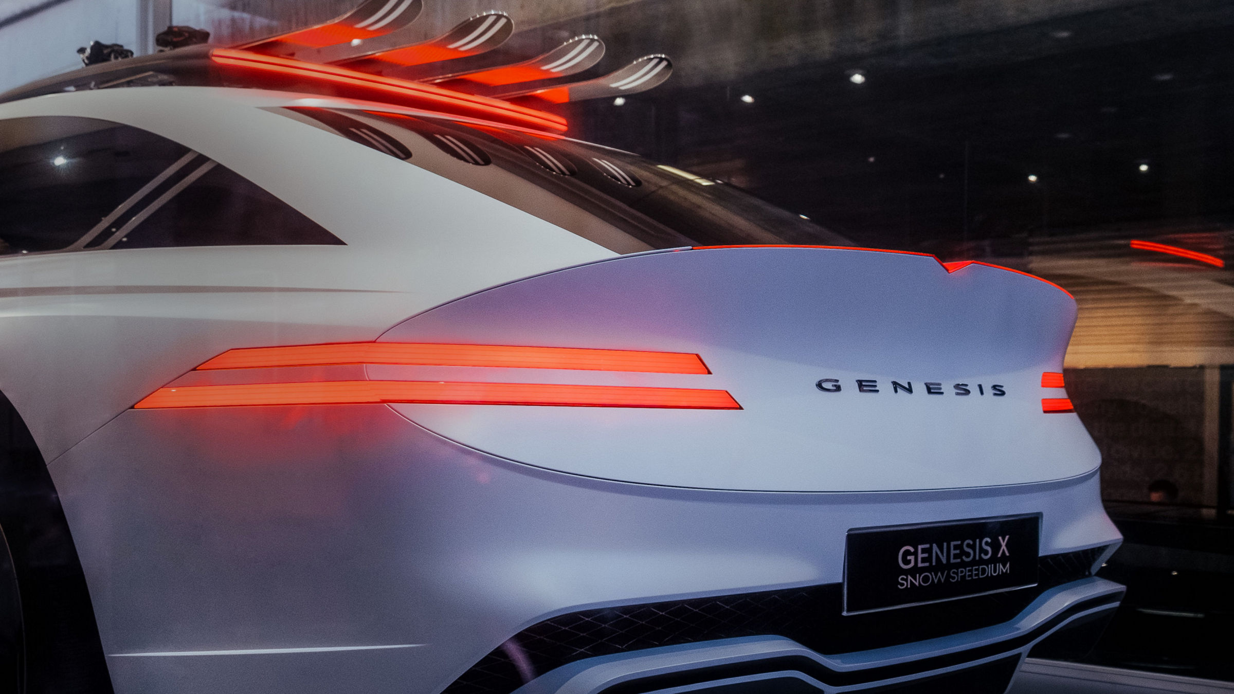 Skiis are atop the roof rack of the white-colored Genesis X Snow Speedium concept car.