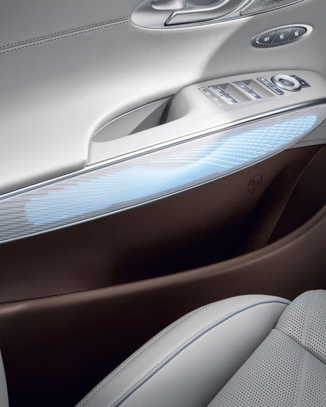 Door panel interior of a luxury car featuring an illuminated trim and premium materials.