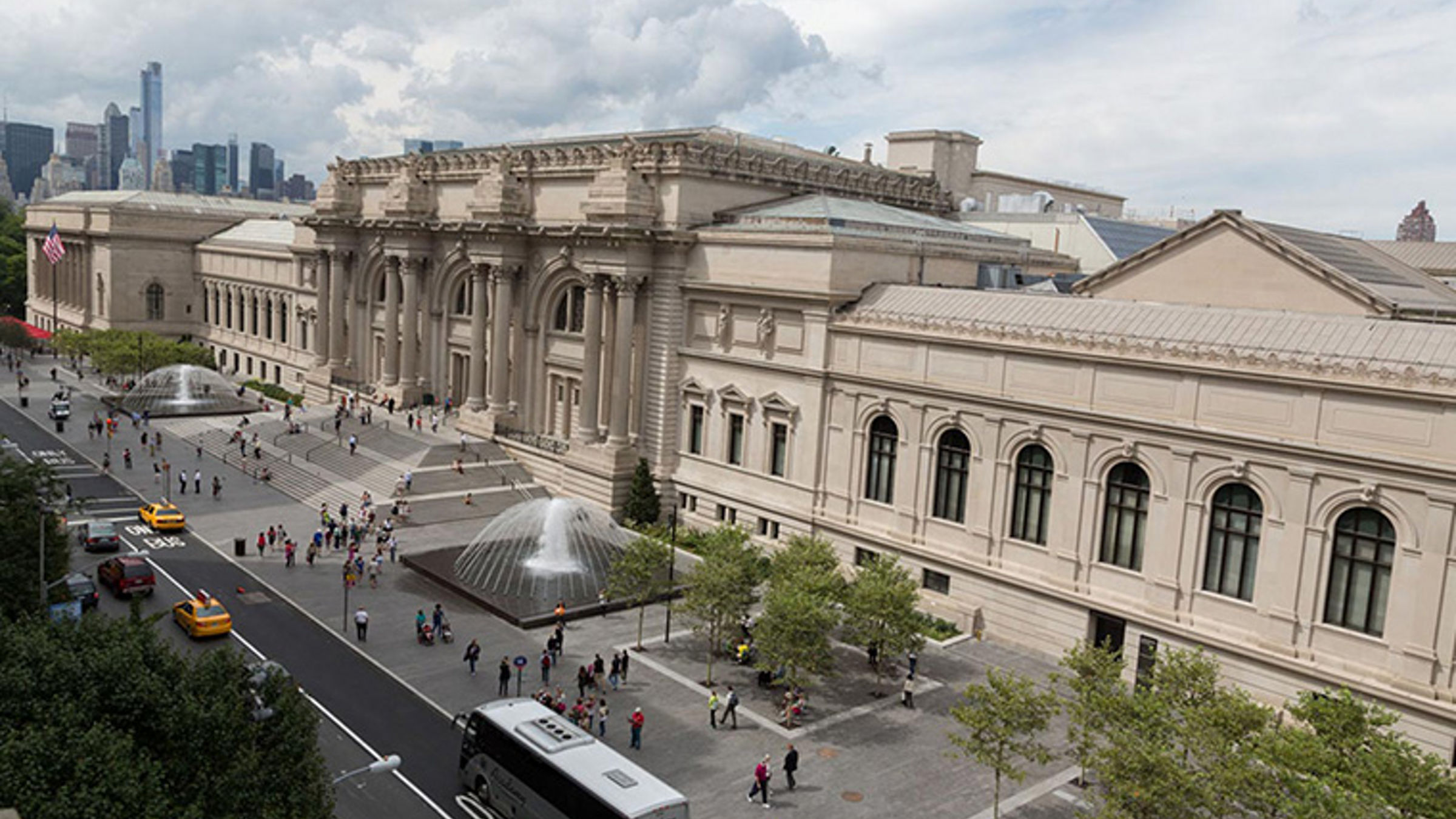 Der Blick auf das Metropolitan Museum of Art ist zu sehen, mit einem Brunnen und Passanten auf dem Platz davor.