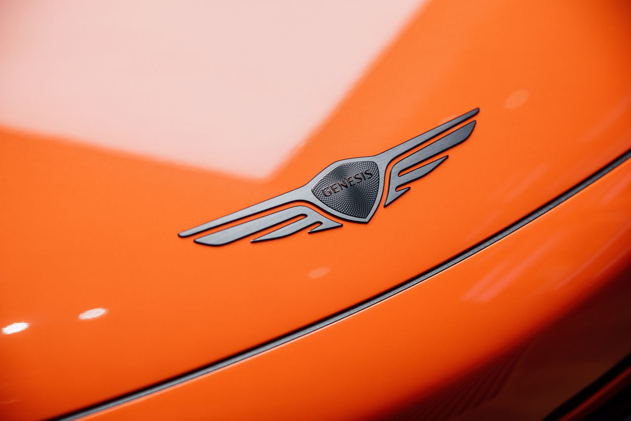 Blick auf das Genesis-Emblem auf der Motorhaube des Genesis GV60 Magma Concept