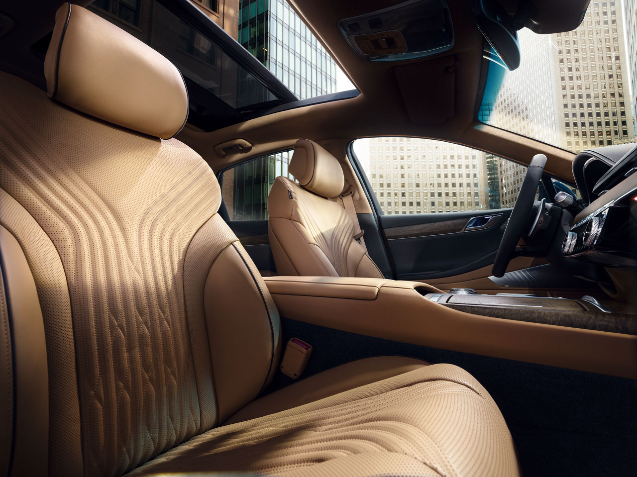 Light brown front seats in a car with skyscrapers in the background