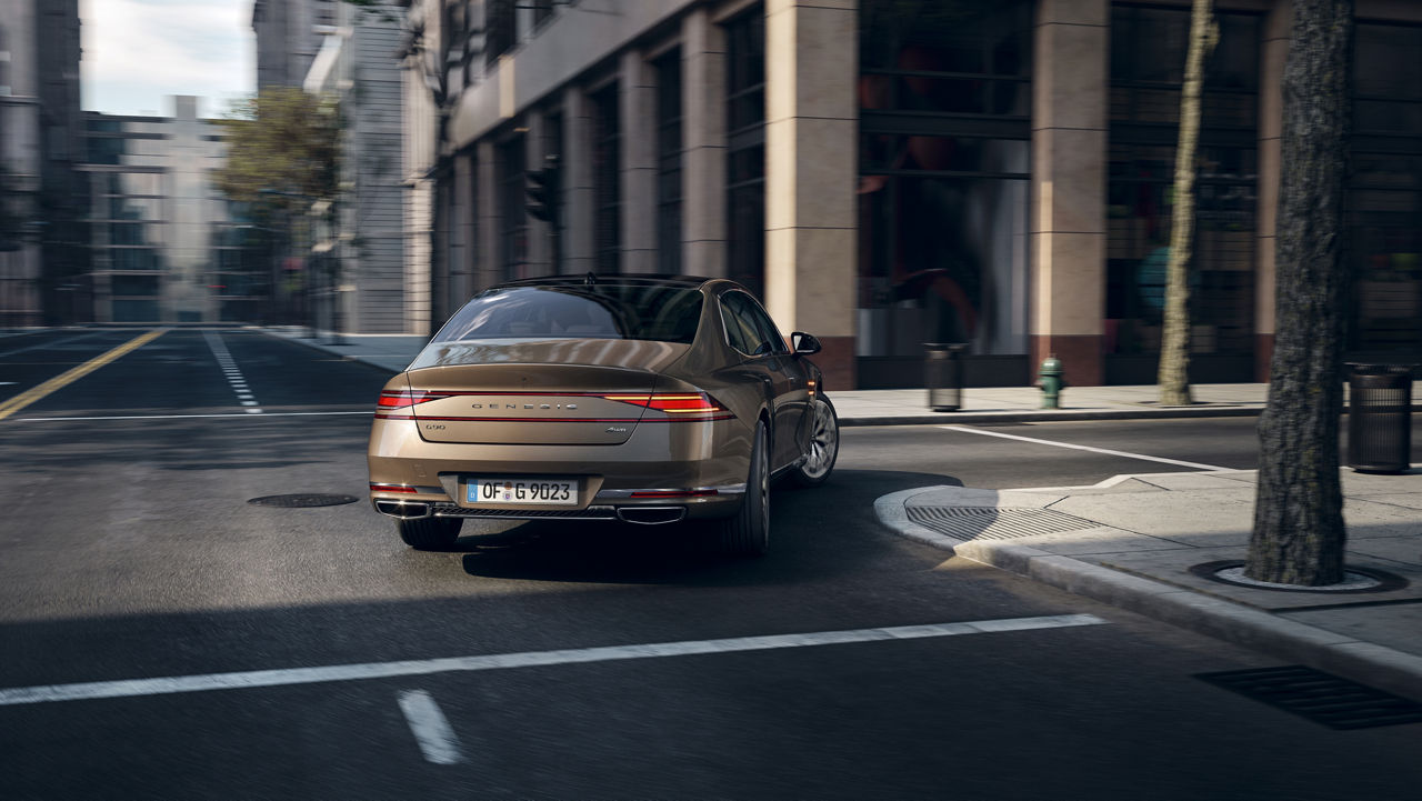 Gold-coloured Genesis G90 turns into a road at an intersection in the city