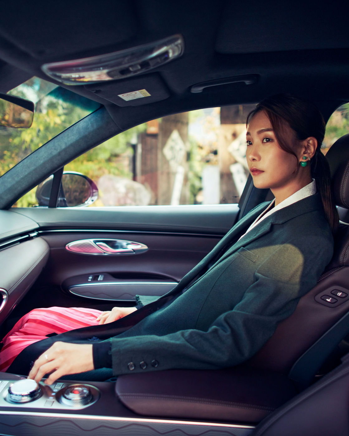  A woman sitting in the passenger seat of a car with a modern and elegant interior.