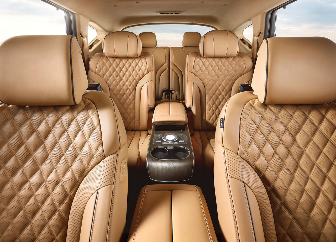 View from the front seats to the rear two rows of seats in a car with a brown-beige interior