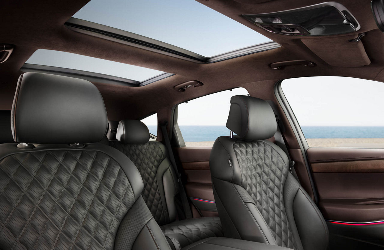 Interior of the Genesis GV80 with black-brown interior with beach and sea in the background