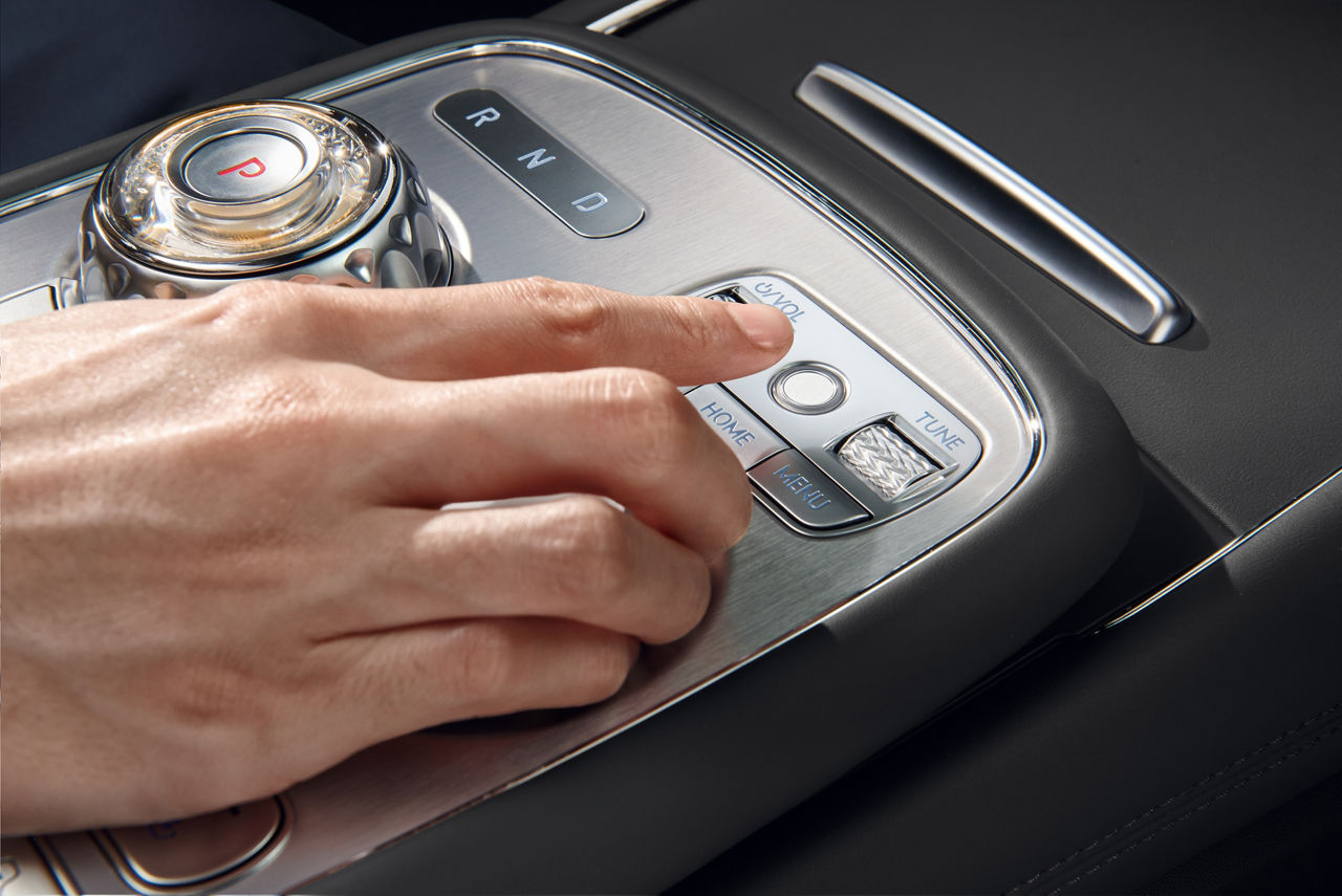 The hand of a person on the front centre console in nappa black of a G90