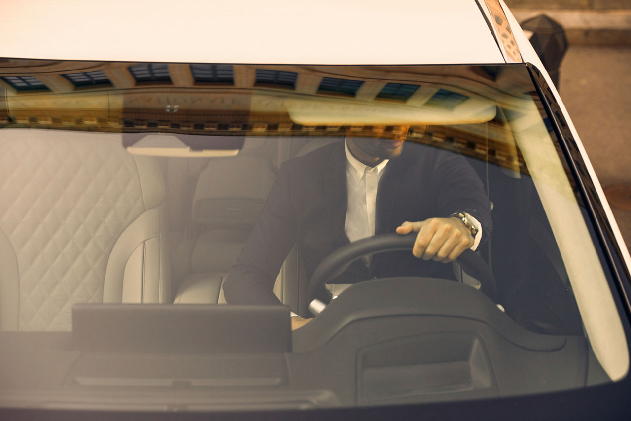 Blick durch die Windschutzscheibe auf einen Mann am Steuer eines Autos