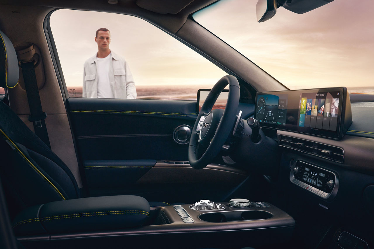 Man looks through the window at the driver's seat of the Genesis GV60