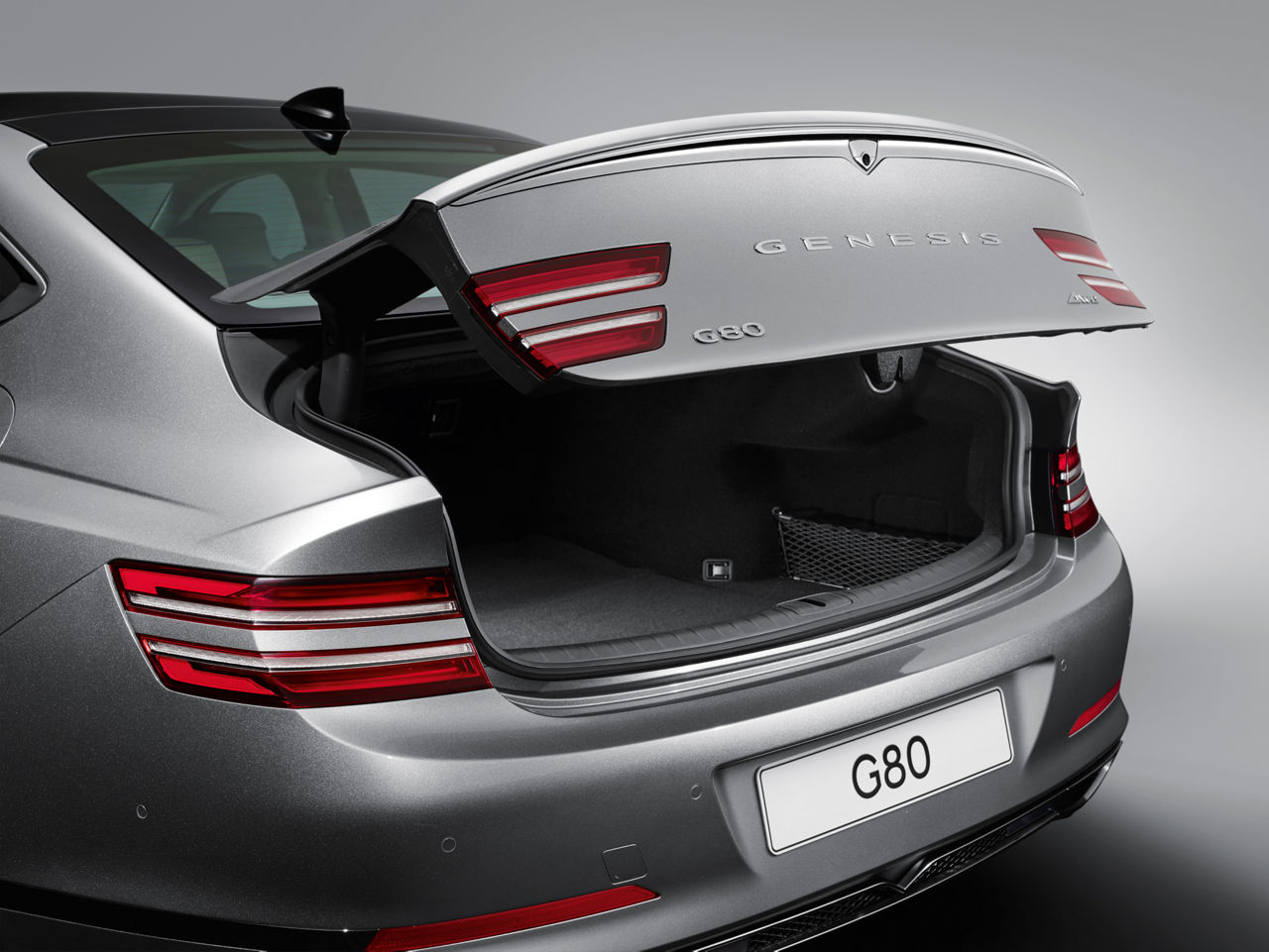 Genesis G80 silver exterior back view with open trunk