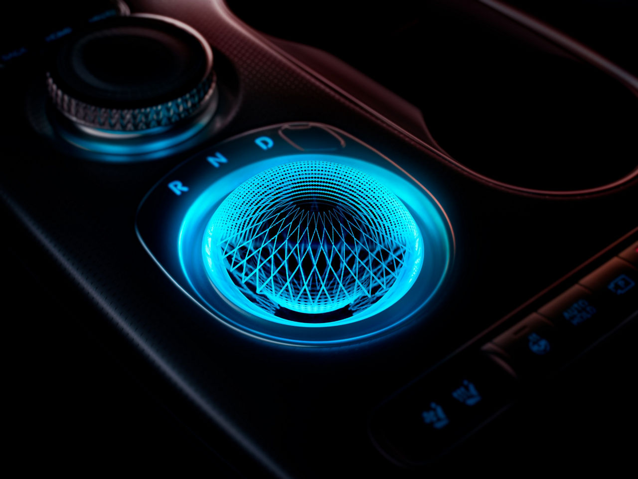 Spherical blue illuminated control element in the centre console of a car
