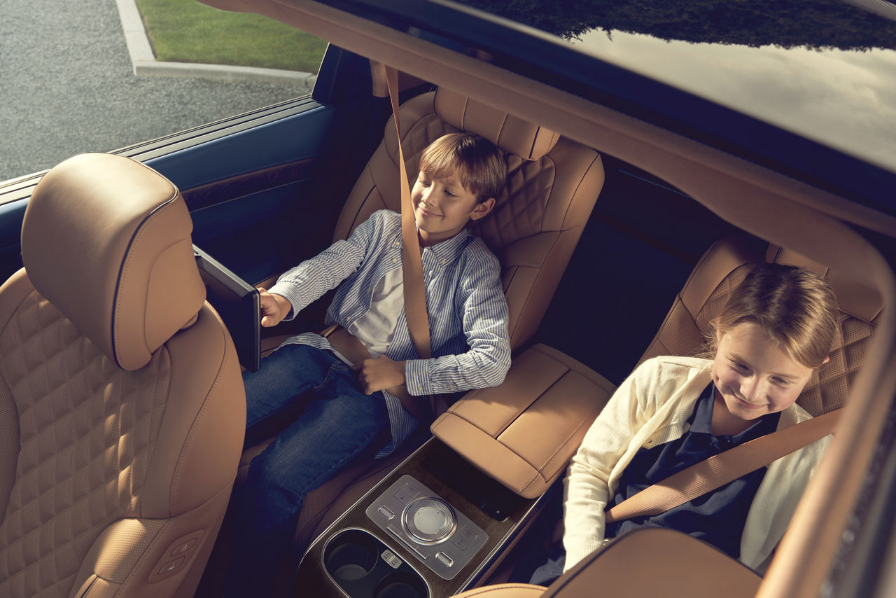 Zwei Kinder sitzen auf den Rücksitzen eines Autos