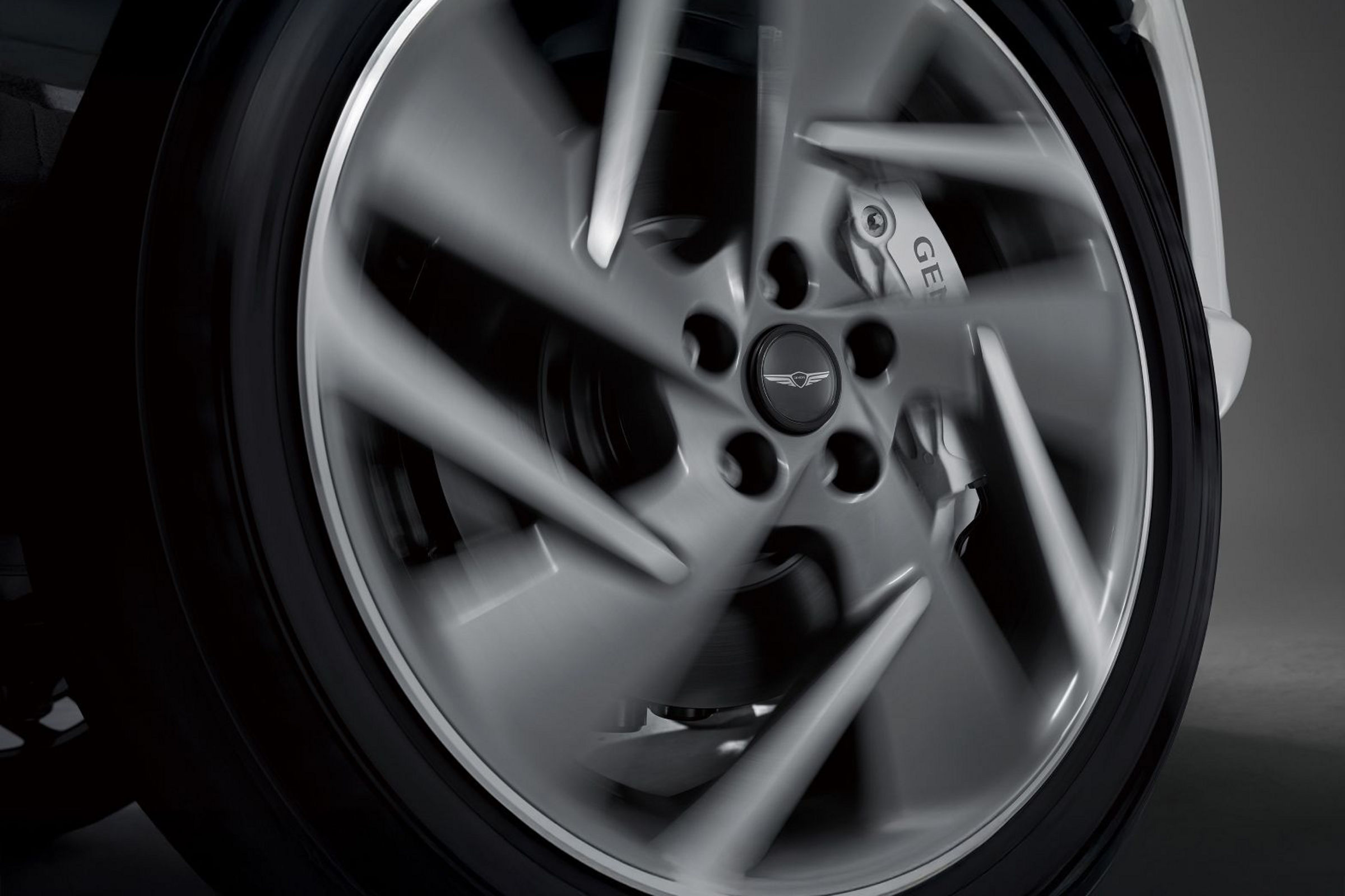  A floating wheel cap with the Genesis emblem can be seen in the middle of the rotating wheel.