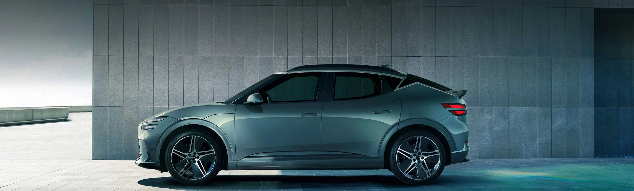 With the blue sky in the background, a Tromso green-colored GV60 is driving toward the side.