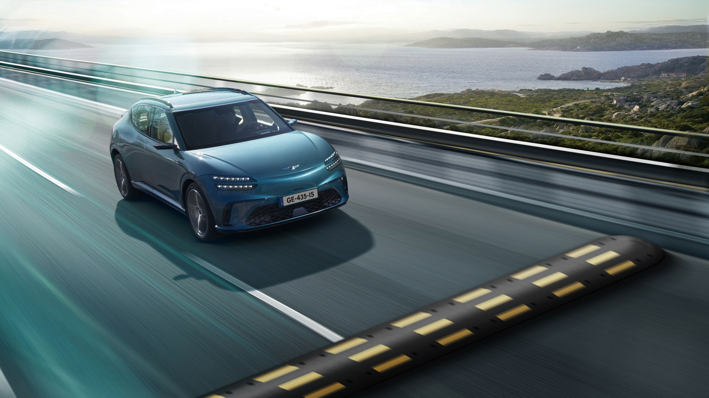  The GV60 vehicle is driving quickly on the road with the natural scenery of the sea and islands in the background. You will see a bump right in front of you.