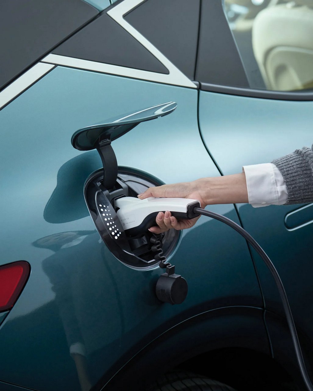 El cargador de Genesis está abierto y las manos de la persona que lo utiliza parecen agrandadas.