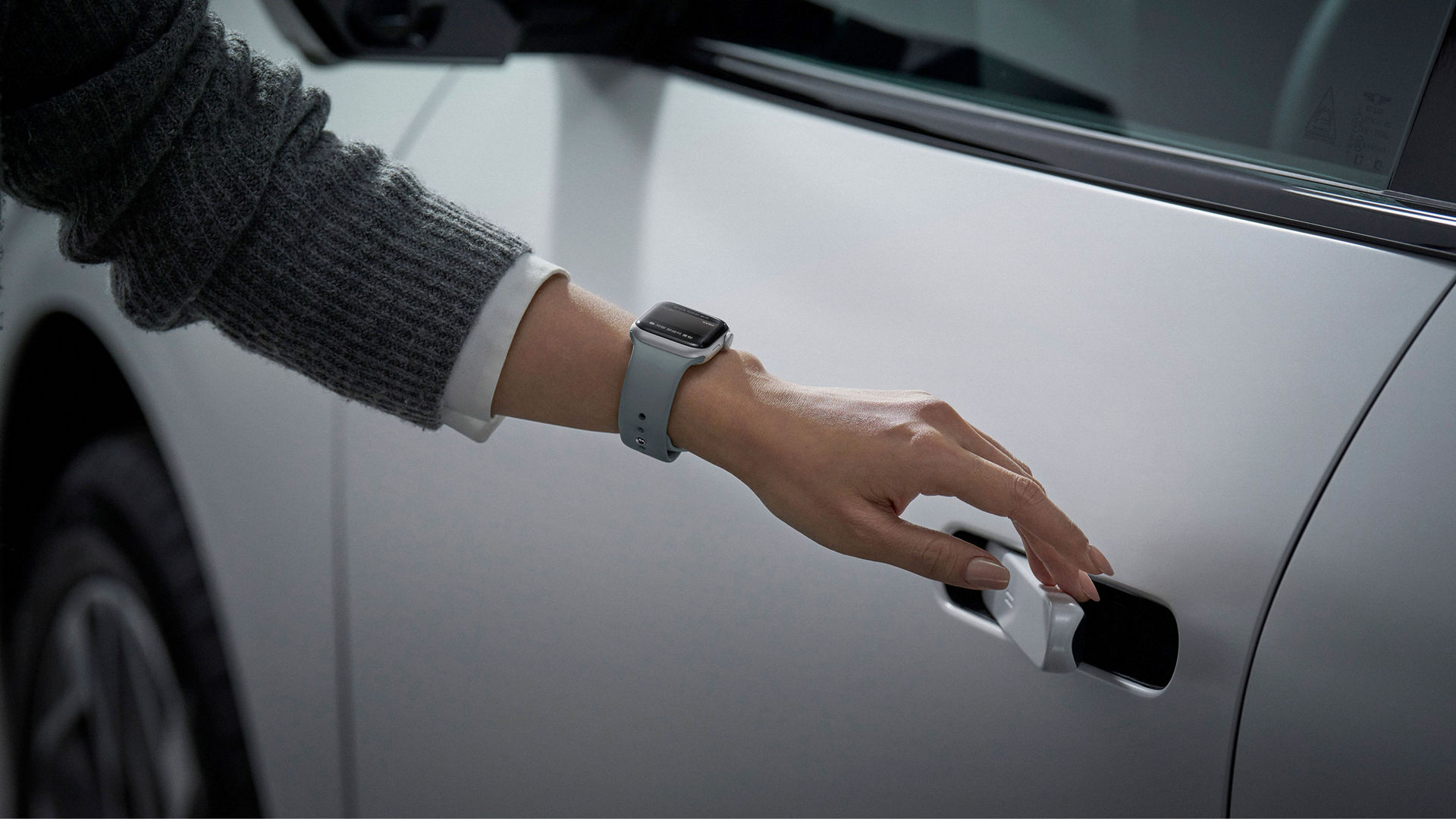 A close-up view of a person's hand trying to unlock a door handle.