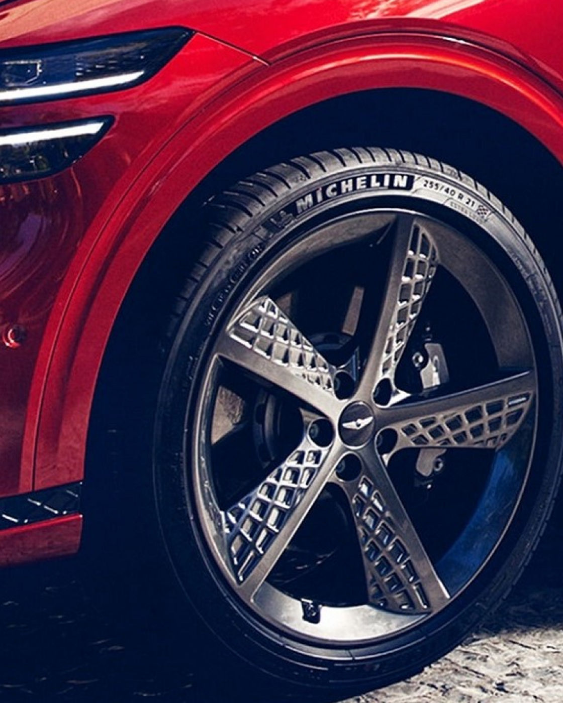 Close-up of a red GV70’s alloy wheel featuring intricate spoke design.