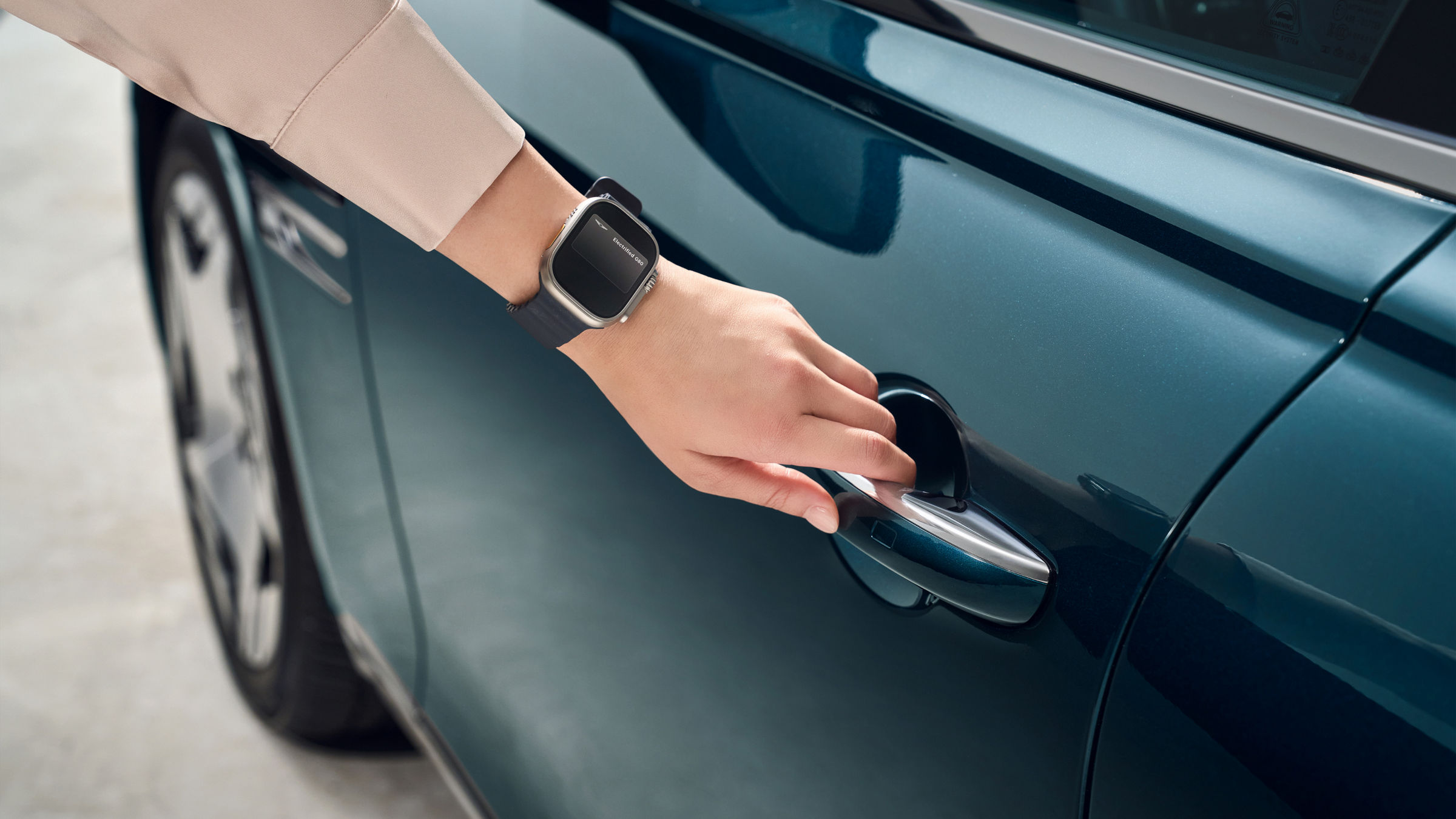 A hand wearing a smartwatch is close to a car door, attempting to remotely operate it. 
