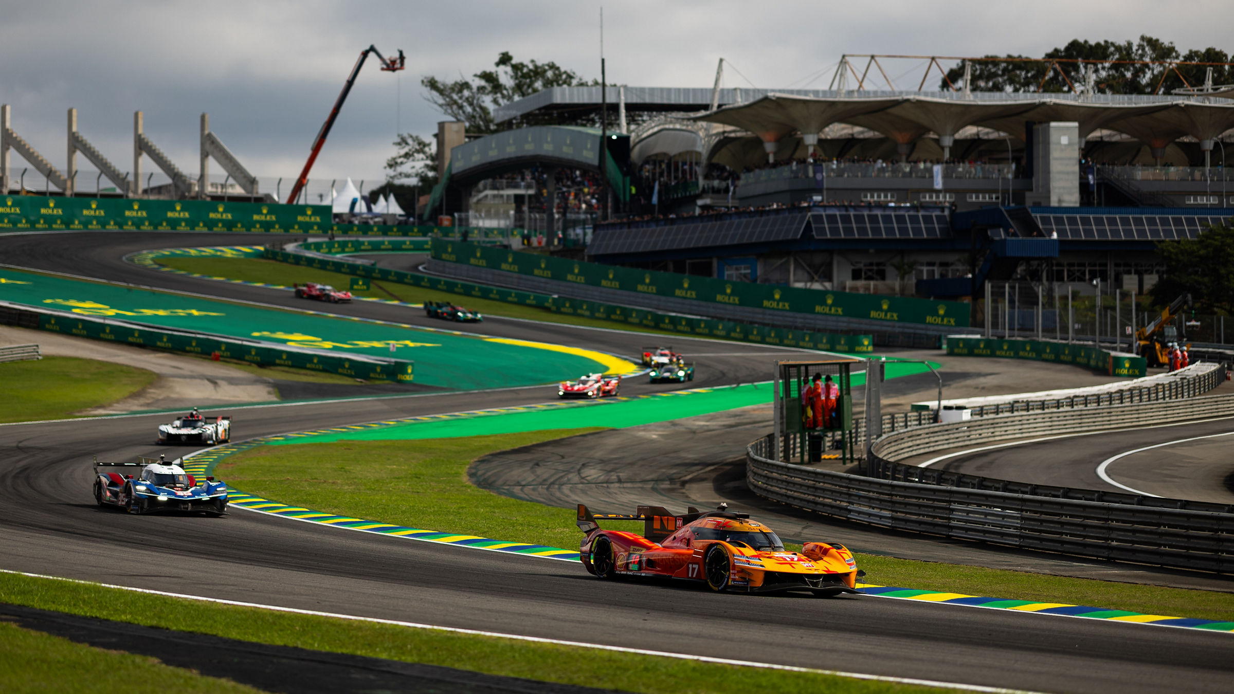 The Genesis GRM-001 leads through a sweeping section of the Interlagos circuit during the FIA World Endurance Championship round in São Paulo, with several rival hypercars following behind.