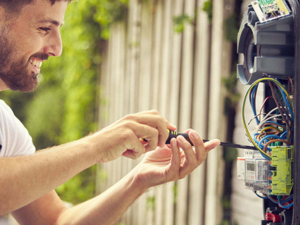 Une personne installe une borne de recharge