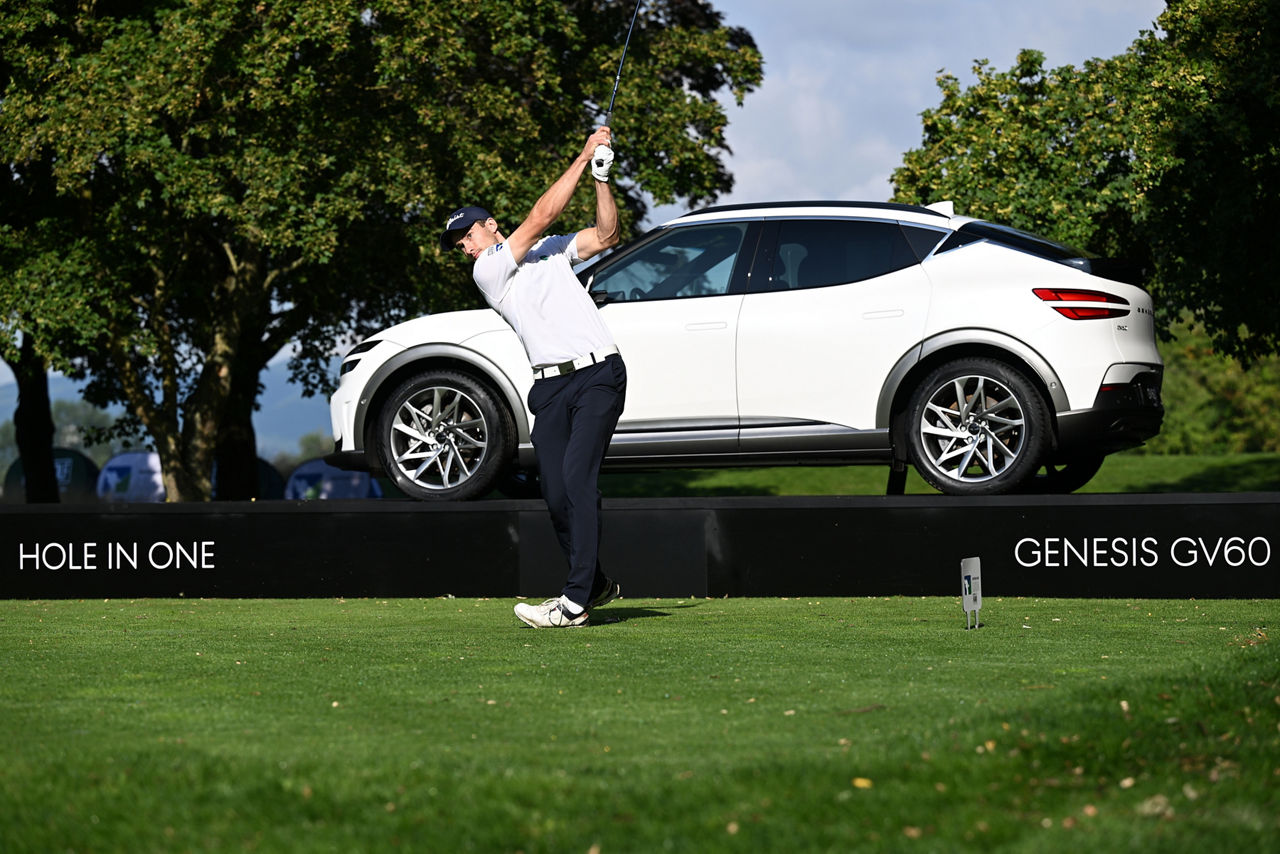 Golfspieler auf einem Golfplatz mit einem weißen Auto im Hintergrund