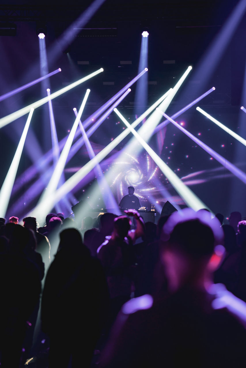 DJ on stage with people and light show at Genesis Myle Festival