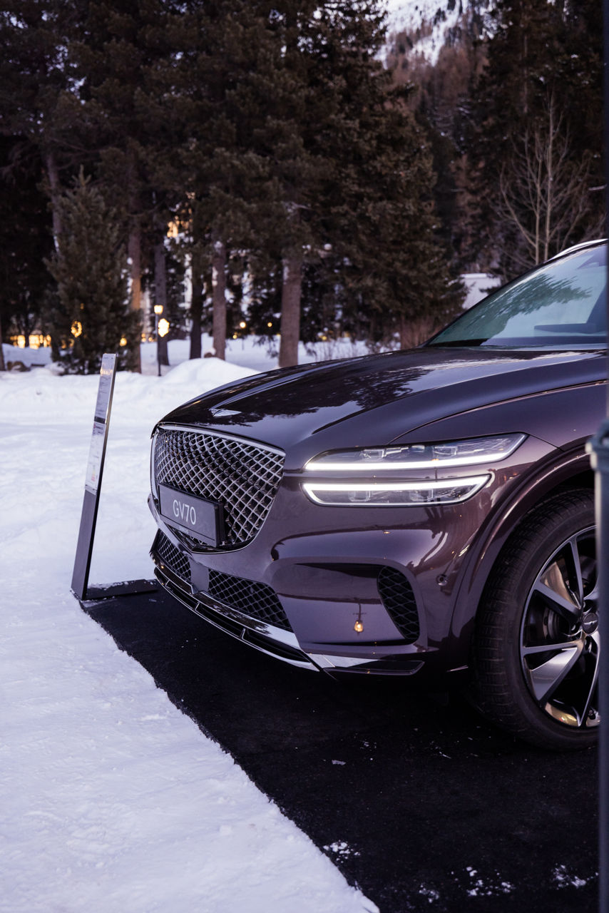 White Turf Event - Burgundy Genesis GV70 garée dehors sur un parking enneigé