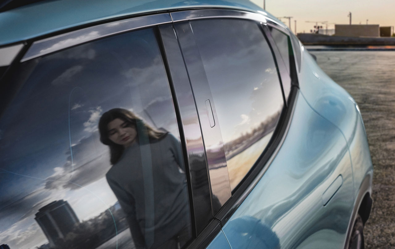 Reflection of a woman in the rear window of a car